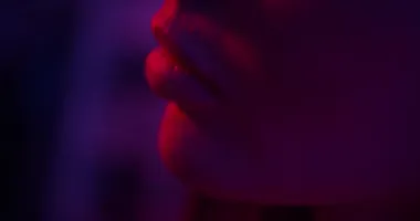 close- up of the models beautiful lips Fashion model girl in neon light