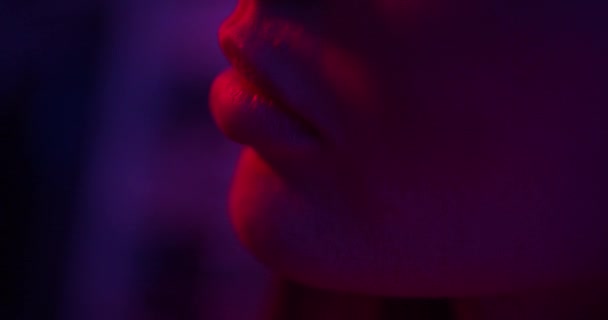 Close-up of the models beautiful lips Fashion model girl in neon light — стоковое видео