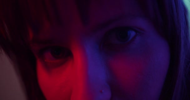 Close-up de uma menina olhando para a câmera Menina modelo de moda em luz de néon — Vídeo de Stock