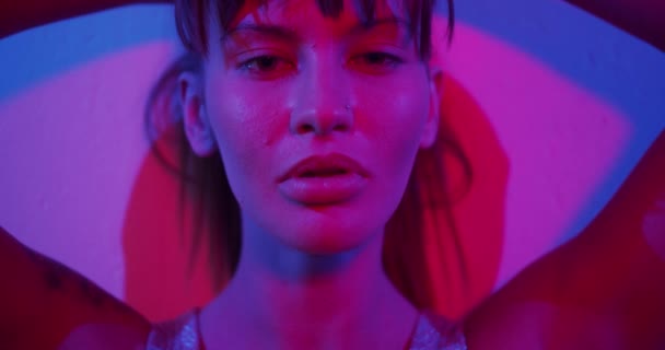 Fashion model girl Turns to the camera and looks in neon light — Stock Video