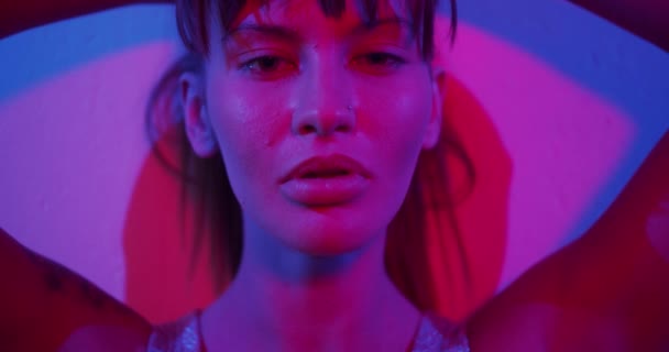 Fashion model girl Turns to the camera and looks in neon light — Stock Footage Fashion model girl Turns to the camera and looks in neon light — Stock Video