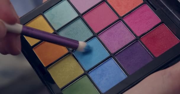 Maquillaje artista sumerge un pincel en la paleta azul — Vídeo de stock