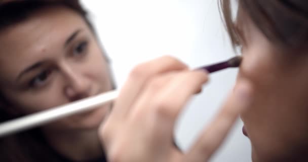 Artista de maquillaje profesional aplicando maquillaje en la cara modelos antes de desfile de moda — Vídeos de Stock