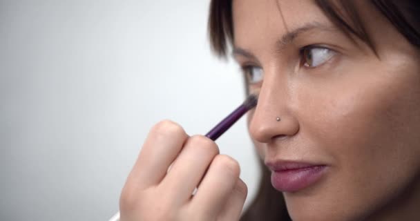 Artista de maquillaje profesional aplicando maquillaje en la cara modelos antes de desfile de moda — Vídeo de stock