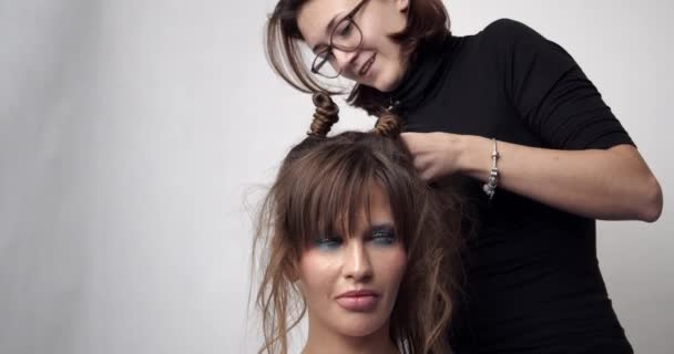 Le coiffeur fait les cheveux des mariées. Coiffure de mariage pour une jeune fille. Styliste faisant coiffure . — Video