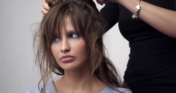 O cabeleireiro faz o cabelo das noivas. Penteado de casamento para uma jovem. Estilista fazendo estilo de cabelo . — Vídeo de Stock