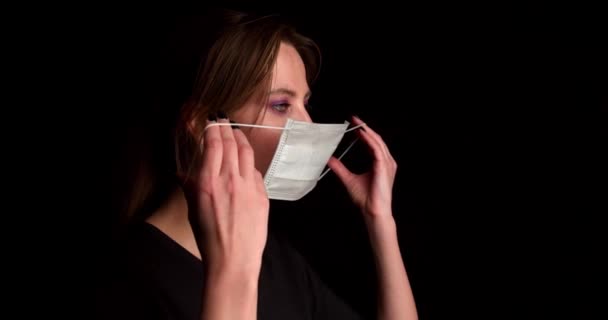 Женщина надевает медицинский портрет маски — стоковое видео
