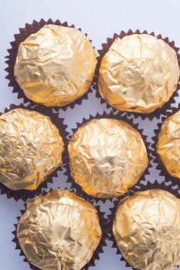 Bir altın folyo kağıt arka plan üzerinde çikolata topu.