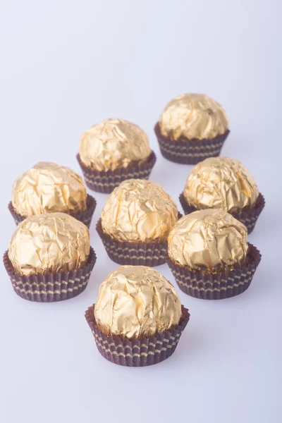 Chocolate ball in a gold foil paper on a background. — Stock Photo, Image