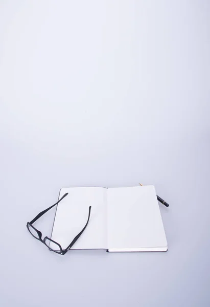 Caderno com óculos e caneta no blackground . — Fotografia de Stock