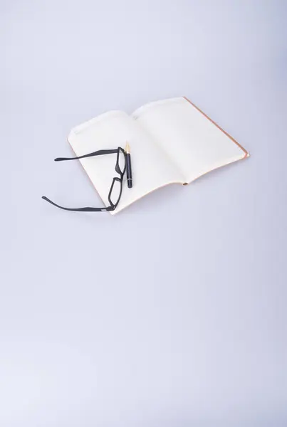 Notizbuch mit Brille und Stift auf dem Schwarzgrund. — Stockfoto