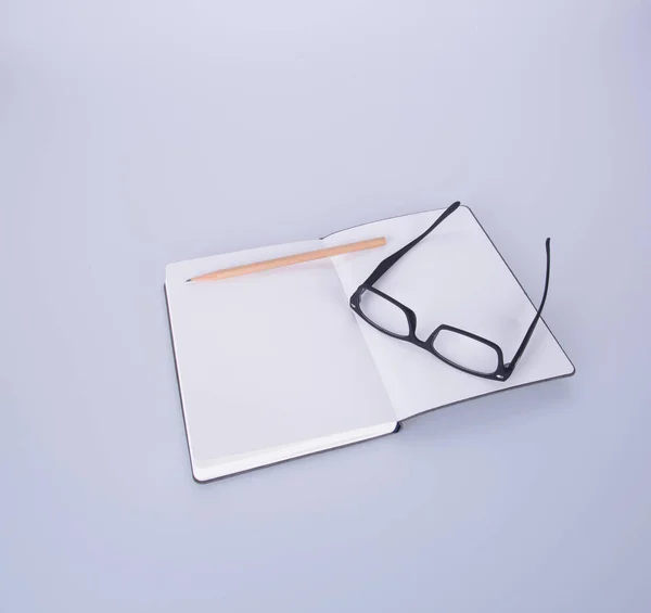 Notebook cu ochelari și stilou pe terenul negru . — Fotografie, imagine de stoc