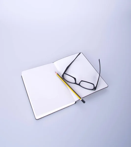 Caderno com óculos e caneta no blackground . — Fotografia de Stock
