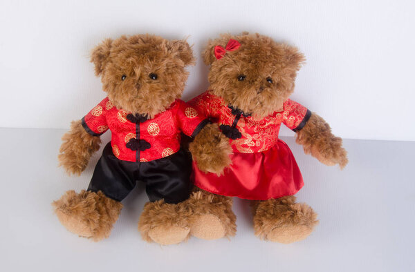 toy or teddy bear with chinese red shirt on background.