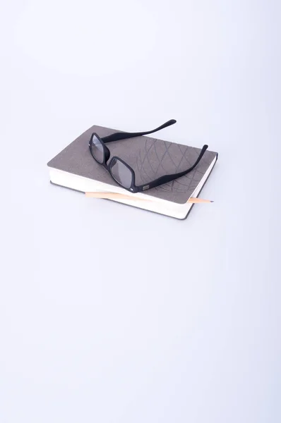 Anteckningsbok med glasögon och penna på blackground. — Stockfoto