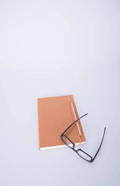 Caderno com óculos e caneta no blackground . — Fotografia de Stock