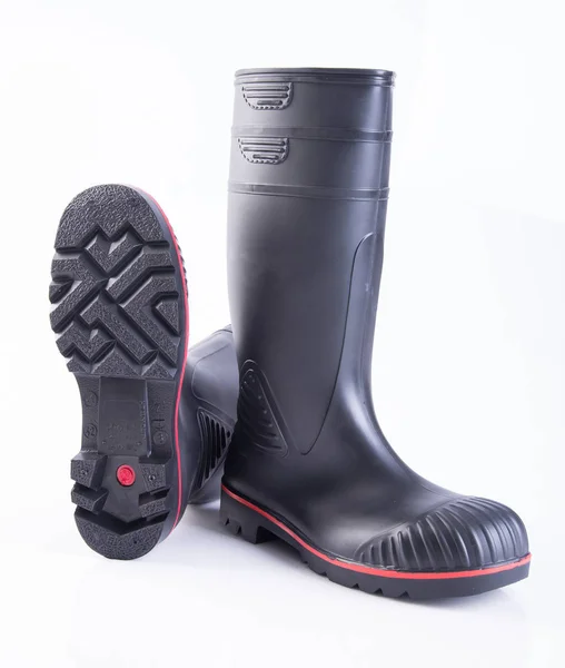Παπούτσι ή μαύρο χρώμα καουτσούκ μπότες σε φόντο. — Φωτογραφία Αρχείου