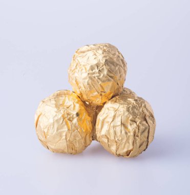 Bir altın folyo kağıt arka plan üzerinde çikolata topu.