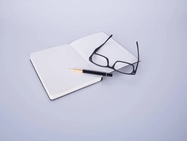 Notebook con gafas y bolígrafo en el blackground . —  Fotos de Stock