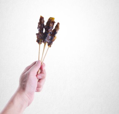 Satay veya Holding el sopa arka plan üzerinde ızgara Satay