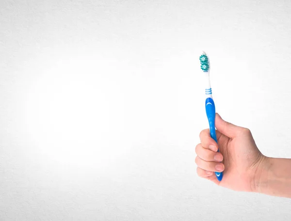 歯ブラシや歯ブラシの背景に手 — ストック写真