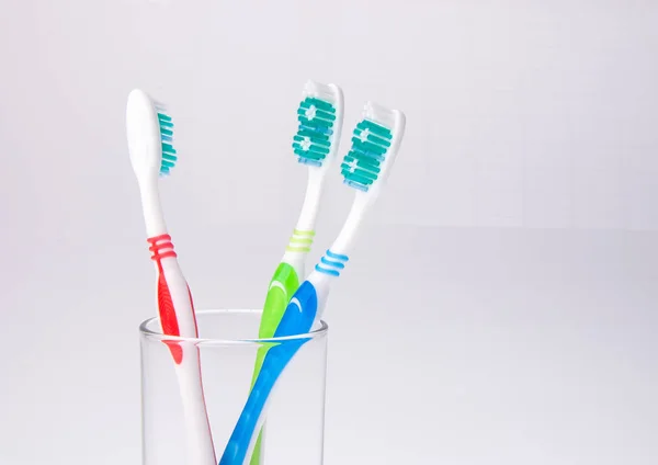 背景にあるガラスのカラフルな歯ブラシ. — ストック写真