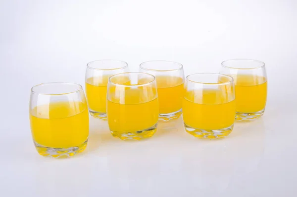 Sucul de portocale în ochelari pe fundal alb . — Fotografie, imagine de stoc