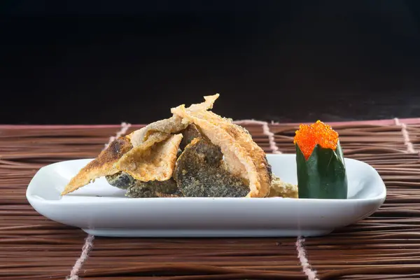 Japanse keuken. gebakken vis huid op de achtergrond — Stockfoto