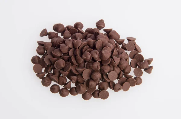 Gli bocconcini di gocce di cioccolato sparsi su uno sfondo . — Foto Stock