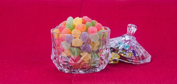 Caramelos. caramelos de gelatina en un recipiente de vidrio sobre un fondo —  Fotos de Stock