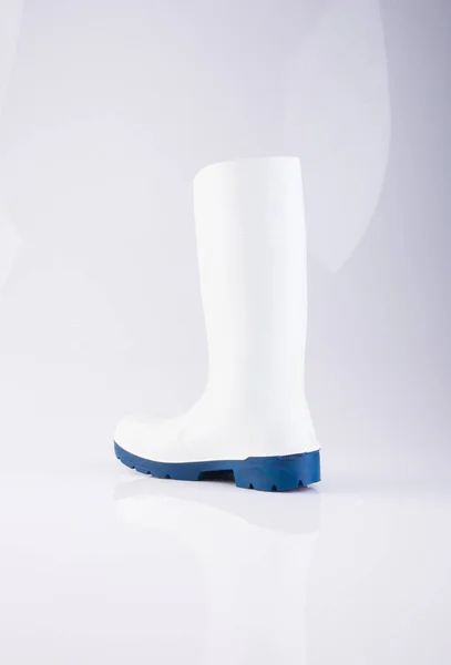 Παπούτσι ή λευκό χρώμα καουτσούκ μπότες σε φόντο. — Φωτογραφία Αρχείου