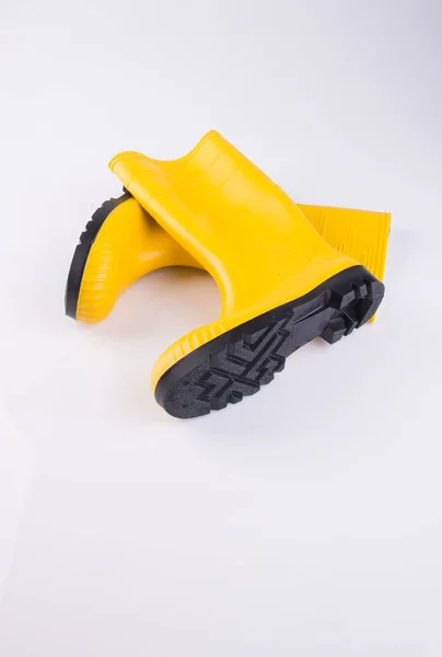 Παπούτσι ή κίτρινο χρώμα καουτσούκ μπότες σε φόντο. — Φωτογραφία Αρχείου