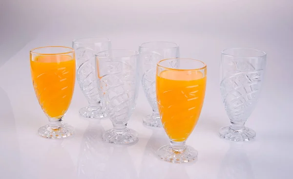 Sumo de laranja em óculos no fundo branco . — Fotografia de Stock