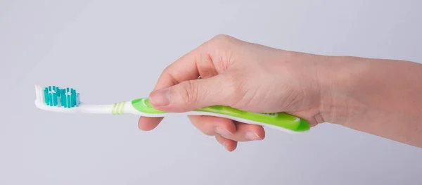 Toothbrush in hand on background. — Stock Photo, Image