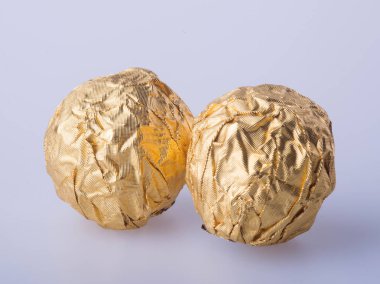 Bir altın folyo kağıt arka plan üzerinde çikolata topu.