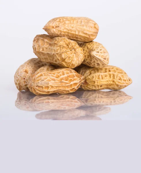 Nüsse oder Erdnüsse und ungeschälte Nüsse auf einem Hintergrund neu. — Stockfoto