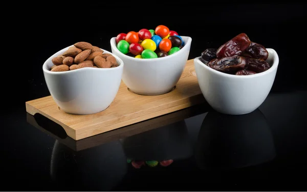 Mandeln mit Schokolade und Datteln auf neuem Hintergrund. — Stockfoto