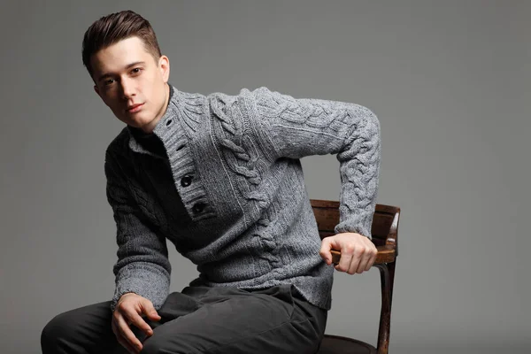 Szexi fiatal férfi meleg kötött sweateron egy szürke háttér. Férfi modell. — Stock Fotó