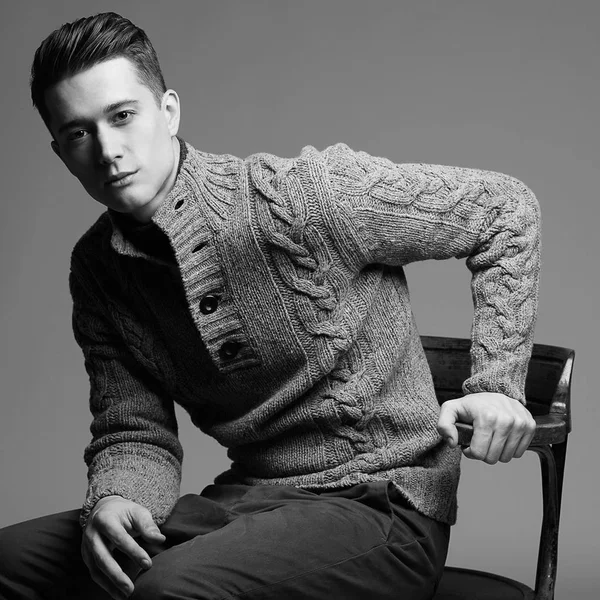 Szexi fiatal férfi meleg kötött sweateron egy szürke háttér. Férfi modell. — Stock Fotó