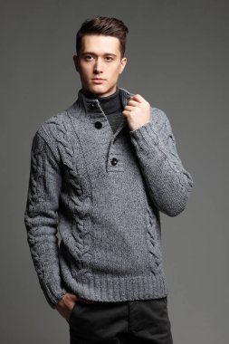 Sıcak örgü sweateron gri bir arka plan seksi genç adam. Erkek model. 