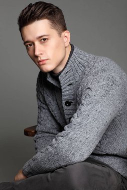 Sıcak örgü sweateron gri bir arka plan seksi genç adam. Erkek model. 