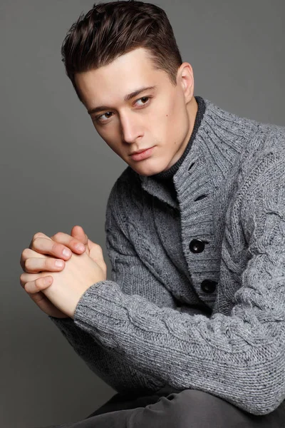 Sıcak örgü sweateron gri bir arka plan seksi genç adam. Erkek model. 