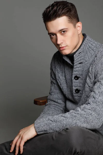 Sıcak örgü sweateron gri bir arka plan seksi genç adam. Erkek model. 