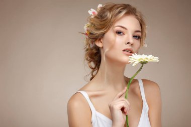güzel kız, izole bir ışık - tüyleri, duygular, kozmetik varicoloured çiçekli gri arka plan üzerinde