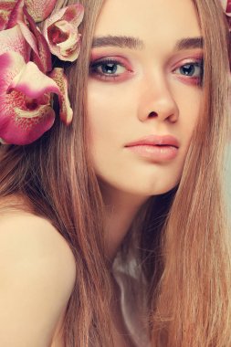 Güzel kız, bir ışık - tüyleri, duygular, kozmetik varicoloured çiçekli mor arka plan üzerinde izole