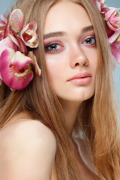 美丽的女孩上一盏灯 紫罗兰色背景与五颜六色的花 化妆品 — 图库照片