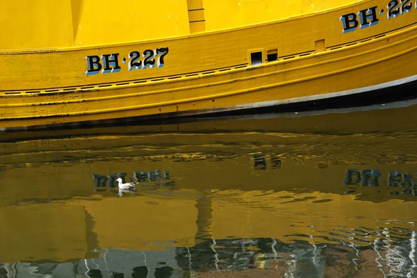 Gula båten reflektion i vatten. Eyemouth i Skottland, Storbritannien. 07.08.2015 — Stockfoto