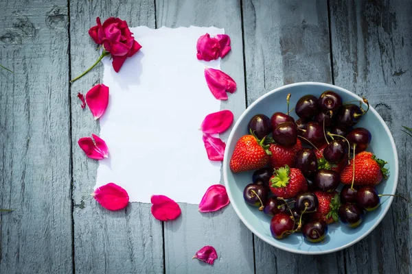 红色的玫瑰花瓣和碗樱桃浪漫爱情背景 — 图库照片