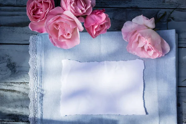 Beautiful, pink roses on wooden, rustic background with white paper and copy space — Stock Photo, Image