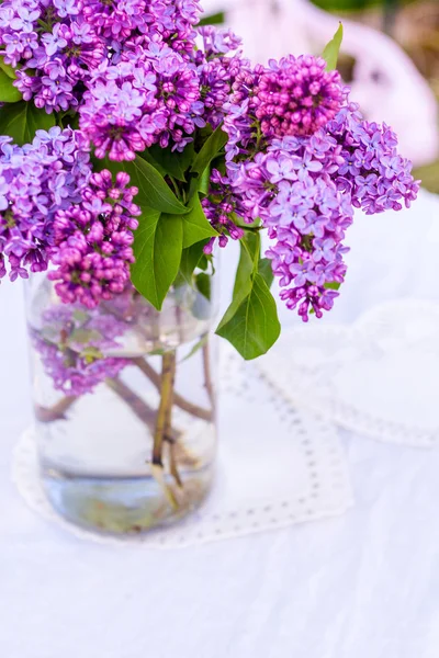 Lindas flores lilás frescas em um vaso de vidro, composição ainda vida — Fotografia de Stock